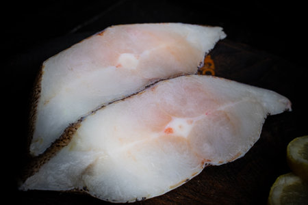 Frozen Greenland halibut steaks on the wood cutting board. Food background. Close up.の写真素材