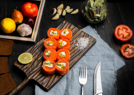 Salmon rolls with cream cheese and pistachios on a wooden cutting board. Luxury catering. Top view.の写真素材