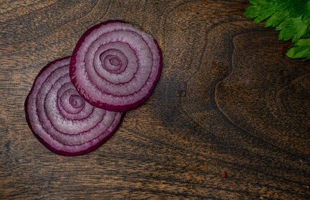 Onion slices on a wooden cutting board. Top view.の写真素材