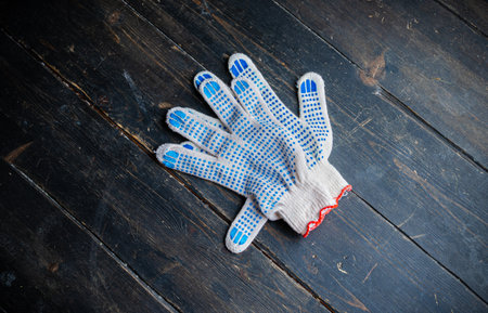 New work gloves on dark wooden table. A pair of cotton glovesの写真素材