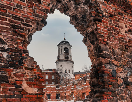 Vyborg Clock Tower. Belfry of the Vyborg Cathedral. View of the clock tower through the ruins of the old templeの写真素材