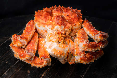 Tasty king kamchatka crab on wood board at brown background