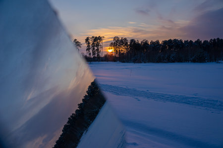 Winter forest at sunset. Reflection of the sun. Landscape in the mirror.の写真素材