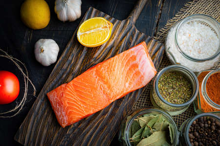 Fresh raw chilled salmon fillet on a woodencutting board. Healthy eating, seafood recipe ingredient.の写真素材