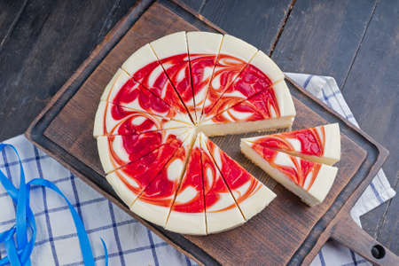 New York Style Cheesecake with Strawberries on a cutting boardの写真素材