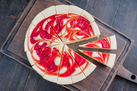New York Style Cheesecake with Strawberries on a cutting boardの写真素材