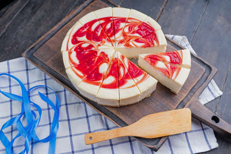New York Style Cheesecake with Strawberries on a cutting boardの写真素材