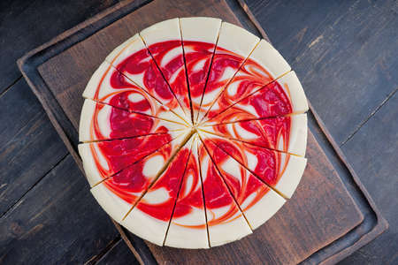 New York Style Cheesecake with Strawberries on a cutting boardの写真素材