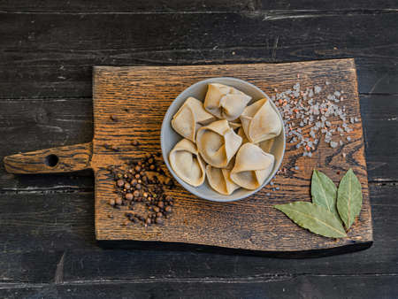 Frozen russian crude pelmen or dumplings in a white bowlの写真素材