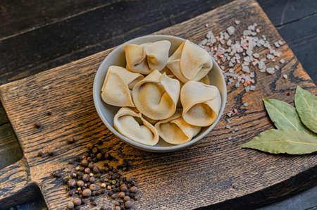 Frozen russian crude pelmen or dumplings in a white bowlの写真素材