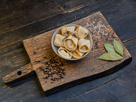 Frozen russian crude pelmen or dumplings in a white bowlの写真素材