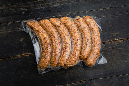 Vacuum-packed meat sausages on a wooden background.の写真素材