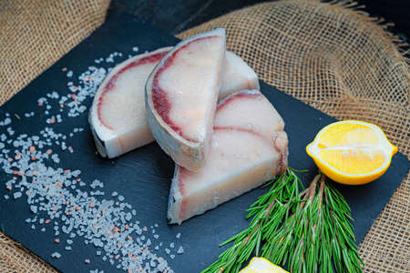 Fresh uncooked blue shark steaks with lemonsの写真素材