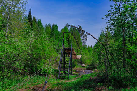 Suspension bridge over a stream in a wild forest . Taganai National Parkの写真素材