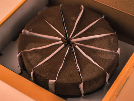 Fresh chocolate cheesecake in opened paper box, close up.の写真素材