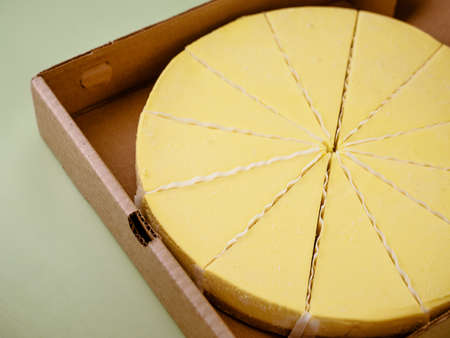 Fresh lemon cheesecake in opened paper box, close up.の写真素材