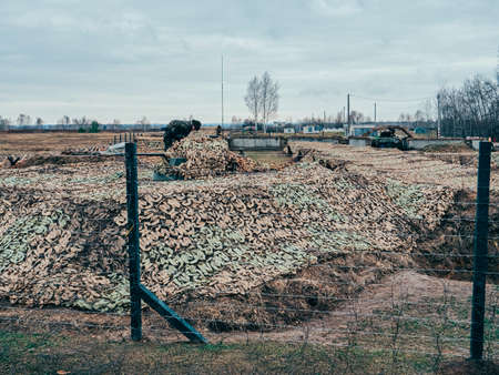 Kazan, Russia. 08 November 2021. Howitzer behind barbed wire, covered with camouflage netting Army exercises of Collective Security Treaty Organization countriesのeditorial素材