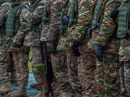 Armed soldiers in camouflage military uniform. Soldiers in formation. Full combat gear.のeditorial素材