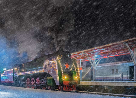 Old steam train in the snow. Vintage train decorated for the Christmasの写真素材