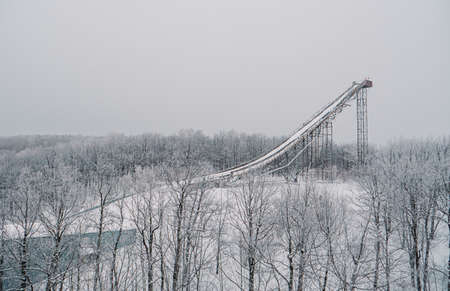Ski jumping slopes or towers in Tatarstan, Russia. Ramps surrounded by snow-covered trees on a hillの写真素材