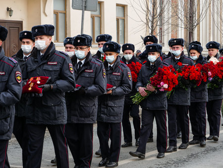 Kazan, Russia. 2022, 10 March. A line of police officers with red carnationsのeditorial素材