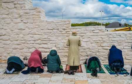 Muslim women pray. Namaz. Women praying at the stone wall