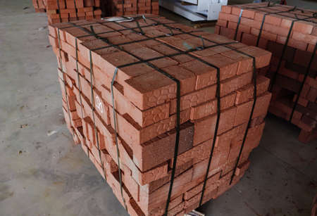 Red building bricks stacked on an outdoor warehouse. Brick stored for building constructionの写真素材