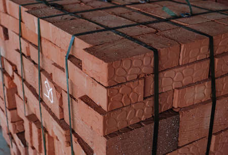Red building bricks stacked on an outdoor warehouse. Brick stored for building constructionの写真素材