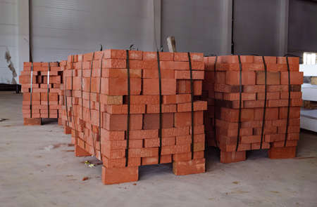 Red building bricks stacked on an outdoor warehouse. Brick stored for building constructionの写真素材