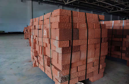 Red building bricks stacked on an outdoor warehouse. Brick stored for building constructionの写真素材