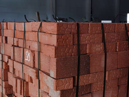 Red building bricks stacked on an outdoor warehouse. Brick stored for building constructionの写真素材