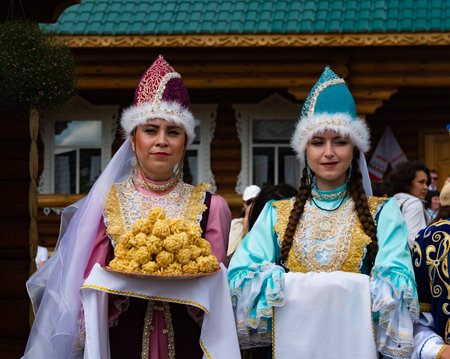 Kazan, Russia. 2022, June 18. Meeting guests according to Tatar customs. Girls offer to taste the chak-chak.のeditorial素材