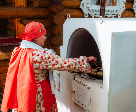 Kazan, Russia. 2022, June 18. A woman cooks traditional flatbread in a Russian stove.のeditorial素材