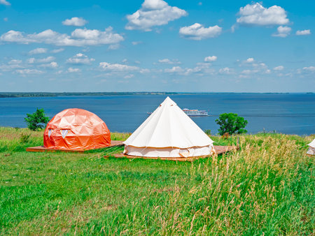 Glamping in a green clearing near the river. Tent house outdoors in Russian glampingの写真素材