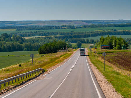 A modern white bus in the countryside on the highway.の写真素材