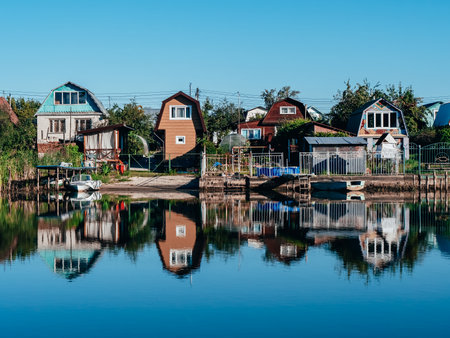 Country houses on the banks of the river. Reflection of houses in the water.の写真素材