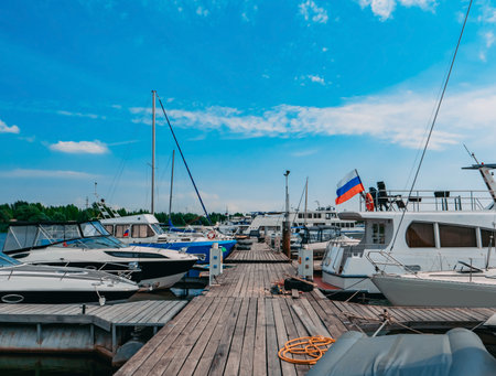 Boats and sailboats moored to a pier in a yacht marina.の写真素材