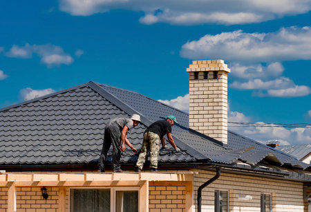 Installation of metal tiles on the roof of the house. Construction of a house.のeditorial素材