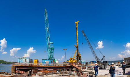 Cranes and pile-driving machines at the construction of a bridge over the Volga River.のeditorial素材