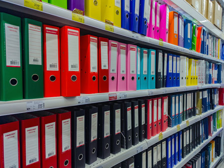 Rows of colorful ledgers in an office supply supermarket. Set of color coded files and binders used by bookkeeper and accountantのeditorial素材