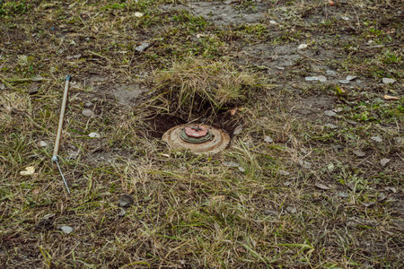 Anti-personnel mine in the field. The process of digging out and demining the device.のeditorial素材