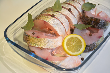 Appetizing sliced fish in a glass tray with the spices.の写真素材
