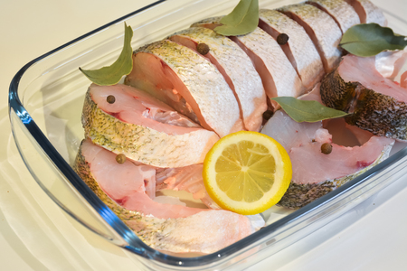 Appetizing slices of fish with spices for cooking close up.の写真素材