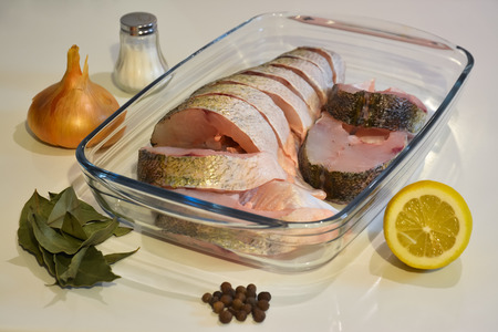 Sliced fish in a glass tray, salt and spices.の写真素材