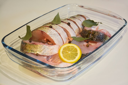Sliced fish in glass tray with spices.の写真素材