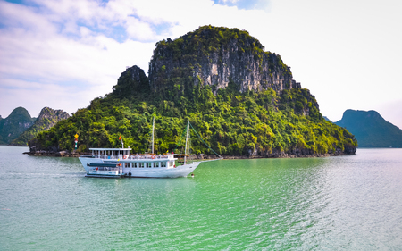 Tourist boat on the background of green rocky island.のeditorial素材