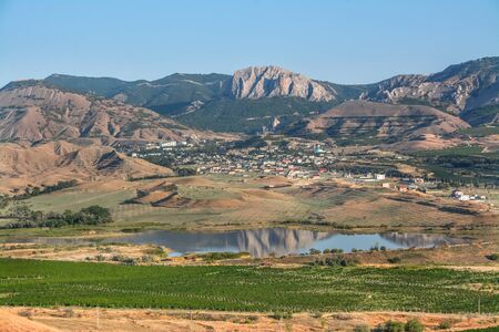 Village in the mountains, lake and vineyards in the foreground.の写真素材