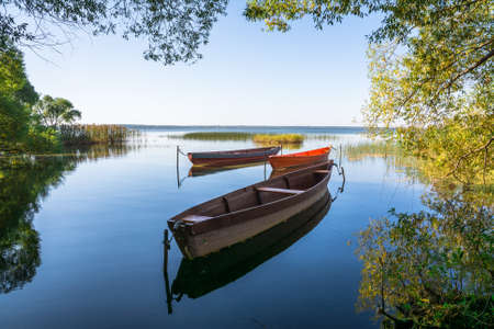 Boats on the water of the lake surrounded by trees.の写真素材