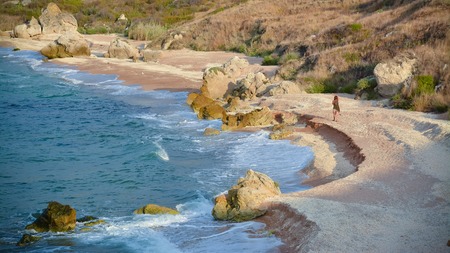 Girl walking on the beautiful beach of shells.の写真素材