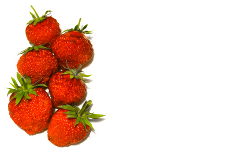 Six ripe strawberries isolated on a white background.の写真素材